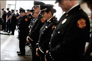 Firefighters bow their heads as a prayer is said in honor of those who have died in the line of duty.
