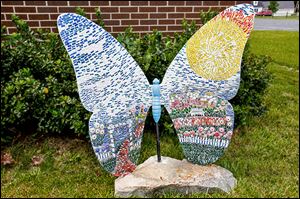 A newly erected mosaic and fiberglass butterfly stands near the DiSalle Real Estate building in downtown Whitehouse.