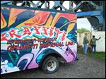  Andrew Kirk, left, and Takisha Townsend, of Toledo’s Neighborhood Beautification Action program, remove graffiti in International Park as the Operation Wipeout Graffiti Removal Unit is unveiled.