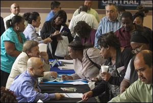 Job seekers inquire for positions at the 12th annual Mission career fair in the skid row area of Los Angeles last week.