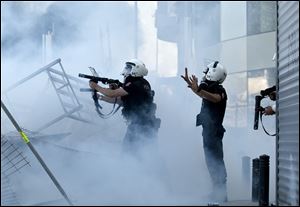 Turkish riot police fire tear gas during clashes at the Taksim Square in Istanbul. Hundreds of police in riot gear forced their way through barricades in the square early today, pushing many of the protesters who had occupied the square for more than a week into a nearby park.