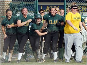 Clay’s Brooke Gyori (with helmet) celebrates with teammates after scoring  the winning run against  Anthony Wayne in the Division I regional semifinal. The Eagles finished 26-4.