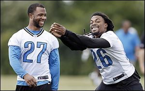 Defensive backs Louis Delmas, right, and Glover Quin laugh at minicamp Tuesday. The Lions hope to bounce back from a dismal 4-12 record last season.