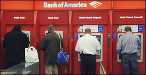 Customers use ATMs at a Bank of America branch office in Boston. A report by the Consumer Financial Protection Bureau released Tuesday said it’s hard for consumers to anticipate and avoid overdraft charges. These charges vary widely from one bank to the next, the report said.