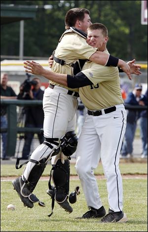 Perrysburg catcher Kyle Durham hugs pitcher Mark Delas after the Yellow Jackets beat Norwalk in the Division I district final.