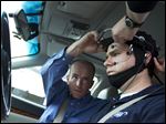  Russ Martin of AAA, is assisted by Joel Cooper, left, hooking the electroencephalographic (EEG)-configured skull cap to the research vehicle during a demonstrations in support of their new study on distracted driving in Landover, Md..
