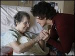  Joyce Rimmelin, right, embraces patient Claire Campbell on her volunteer rounds at ProMedica's Ebeid Hospice Residence in Sylvania. 