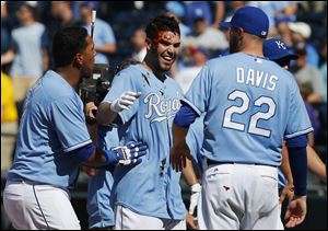 Kansas City Royals' Eric Hosmer, middle, gets covered with 