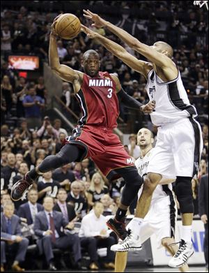 Miami Heat's Dwyane Wade is pressured by San Antonio Spurs' Tim Duncan.