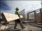  Construction worker Miguel Fonseca carries lumber as he works on building a house in Chula Vista, Calif. Framing lumber now costs 67 percent more than it did at its low price point in 2009.