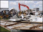  Neighbors and friends help clear debris from barns that were destroyed  on Jim and Marty Behrman’s property during an overnight storm on County Road H in Deshler, Ohio. 