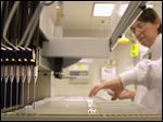  A technician loads patient samples into a machine for testing at Myriad Genetics in Salt Lake City. DNA samples are moved by the eight-needle apparatus. 