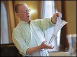  Insured Professional Antique Appraiser Richard Stegman discusses the value of a hand-cut Libbey Glass vase as he offers appraisals on objects brought by local residents to the DeGage Jazz Cafe during the Maumee Valley Historical Society fund-raiser.