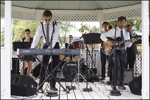 Edward Bean, center left, leads The Gazebo as they play for hundreds of local residents; the band, comprised of Perrysburg graduates, is just one playing near the Commodore Building every Thursday throughout the summer.  
