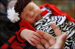 Columbus Grove, Ohio, resident Chad Bingley holds the hand of his newborn daughter, Kyra.