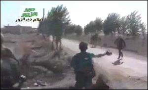 In this amateur video provided by a group which calls itself Ugarit News, Syrian rebels cross a road during a raid on the village of Hatla, Syria, Wednesday.