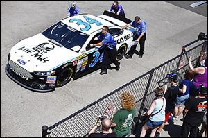 Miss Coors Light, Rachel Rupert, checks out Carl Edward's ride after Edwards earned the pole position for Sunday's race at Michigan International Speedway.