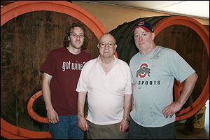 Three generations of the Heinemans, Dustin, his grandfather Louie, and his father Edward, stand in front of oak barrels from the 1940s inside the Heineman's Winery at Put-In-Bay, Ohio.  The winery is Ohio's oldest family owned winery.