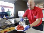  Jason Obregon makes strawberry shortcake during the 75th annual Holland Strawberry Festival at the Community Homecoming Park. Most of the fund-raiser’s proceeds go to a children’s charity.