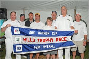 Rear commodore John Sokol, left, and vice commodore Tom Kaintz, second from right, present a flag to the winning crew of the Governor’s Cup after the Mills Trophy Race. Crew members include, beginning second from left, Tom Morgan, Steve King, John Bollin, Robert Bollin, Joe DiMasso, and Bill Bollin, far right.