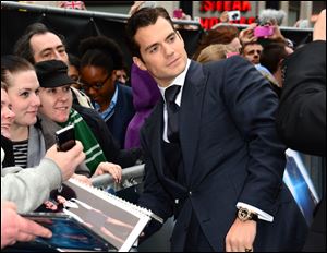 Actor Henry Cavill signs autographs for fans at the European premiere of 'Man Of Steel' in London on Wednesday.