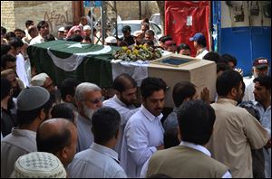 People carry the flag-wrapped casket of a high-ranking government official who was killed in Saturday's bombing at the Bolan Medical complex in Quetta, Pakistan, Sunday, June 16, 2013. The radical Lashkar-e-Jhangvi group claimed responsibility for the attacks on the hospital and a women's university bus.