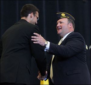 Whitmer High School rising senior Casey Holsten, left, shakes hands with Bob Oehlers, a 1985 Whitmer High School alumnus and 1989 West Point graduate, after introducing him during the Buckeye Boys State Ecumenical Church Service at Bowling Green State University.