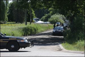 Law enforcement officials block the street to the scene in Oakland Township, Mich., where officials search for the remains of Teamsters union president Jimmy Hoffa.