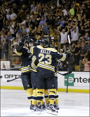 Boston Bruins center Chris Kelly (23) and celebrates a goal by Boston Bruins left wing Daniel Paille, hidden, during the second period in Game 3 of the NHL hockey Stanley Cup Finals against the Chicago Blackhawks in Boston.