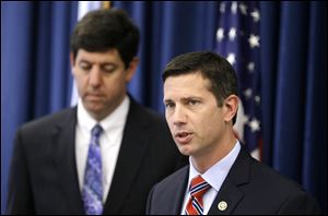 FBI Assistant special agent Eric Smith, right, answers questions during a news-conference about three people arrested on charges of enslaving a disabled young mother and her daughter. U.S. attorney Steven M. Dettelbach is at left.