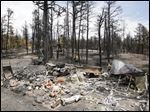  Firefighters are pictured beyond a burned structure as they work hot spots on the Black Forest wildfire north of Colorado Springs, Colo., on Monday.