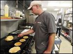  Sylvania Township Firefighter Brad Mauk flips pancakes on the stove during the Sylvania Firefighters IAFF local 2243 annual pancake breakfast  at Toledo Elks Lodge #53.