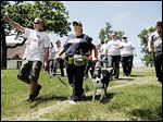  Tracy Finley of Toledo points as he walks with Ft. Wayne, Ind,. resident Gale St. John and her trained cadaver dog, Simon, at Navarre Park. The group searched the park Wednesday for Elaina Steinfurth.
