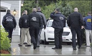 State and local police gather outside the home of New England Patriot's NFL football player Aaron Hernandez in North Attleborough, Mass., Tuesday.