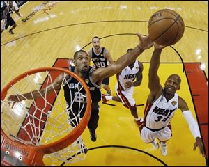 San Antonio Spurs center Boris Diaw (33) of France, blocks a shot to the basket by Miami Heat small forward LeBron James (6) during the first half of Game 6 of the NBA Finals basketball game.