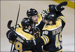 Boston Bruins center Rich Peverley, right, celebrates his goal against the Chicago Blackhawks with left wing Daniel Paille (20) and center Tyler Seguin (19) during the first period in Game 4.