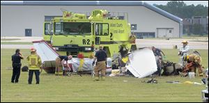 Emergency personnel looks over the scene of a plane crash at Oakland International Airport in Waterford, Mich.