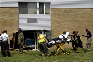 Members of the Toledo Fire Department help an injured man on a stretcher after the incident Friday.