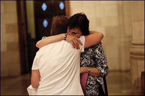 Mary Kay Smith, organizer of the Helpers of God's Precious Infants group,  hugs a parishioner after the Mass at Rosary Cathedral in Toledo.