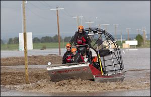 A search and rescue boat carries rescued passengers from a flooded industrial site near highway 543 north of High River, Alberta, Canada on Friday.