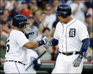 Detroit’s Miguel Cabrera, right, is welcomed at home plate by teammate Brayan Pena after hitting a three-run home run.