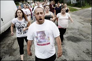 Toledo resident Carl Padgett leads more than 100 people in a chant, saying ‘bring Elaina home.’ The vigil for Elaina Steinfurth, who has been missing since June 2, was Saturday in East Toledo.