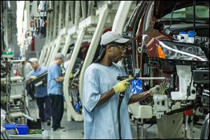 Workers assemble Volkswagen Passat sedans at the German automaker's plant in Chattanooga, Tenn. VW calls the plant a model for energy conservation and efficient production, but officials are mum about whether the facility is in line to produce a new crossover SUV.