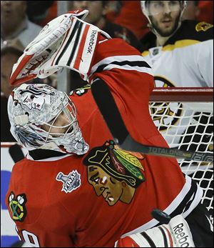 The puck, shot by Boston Bruins defenseman Zdeno Chara (33) gets by Chicago Blackhawks goalie Corey Crawford (50) for a goal in the third period.