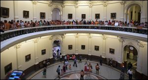 A large crowd, many wearing Planned Parenthood T-shirts that read “Stand with Texas Woman,” wait in line to enter the house chambers at the Texas State Capitol in Austin, Texas on Sunday.