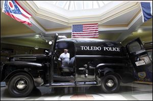 Mark Heilman of Toledo looks at the antique Toledo police car in the middle of the Toledo Police Museum. Sunday's car show also included old cruisers on loan from Cleveland.