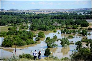 Residents look out from Scholten Hill as water floods an area of the River Flats in Medicine Hat, Albert on Sunday.