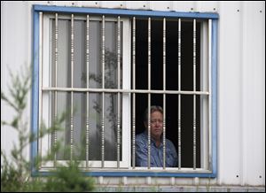American Chip Starnes, co-owner of Specialty Medical Supplies, looks out from a window after he was held hostage by workers inside his plant at the Jinyurui Science and Technology Park in Qiao Zi township of Huairou District, on the outskirts of Beijing.