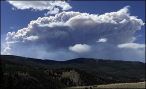 Wildfire smoke plumes above Del Norte Peak.  The fire, near a popular summer retreat in southern Colorado, continues to be driven by winds and fueled by dead trees in a drought-stricken area, authorities said.