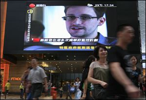 A TV screen shows a news report of Edward Snowden, a former CIA employee who leaked top-secret documents about sweeping U.S. surveillance programs, at a shopping mall in Hong Kong Sunday.